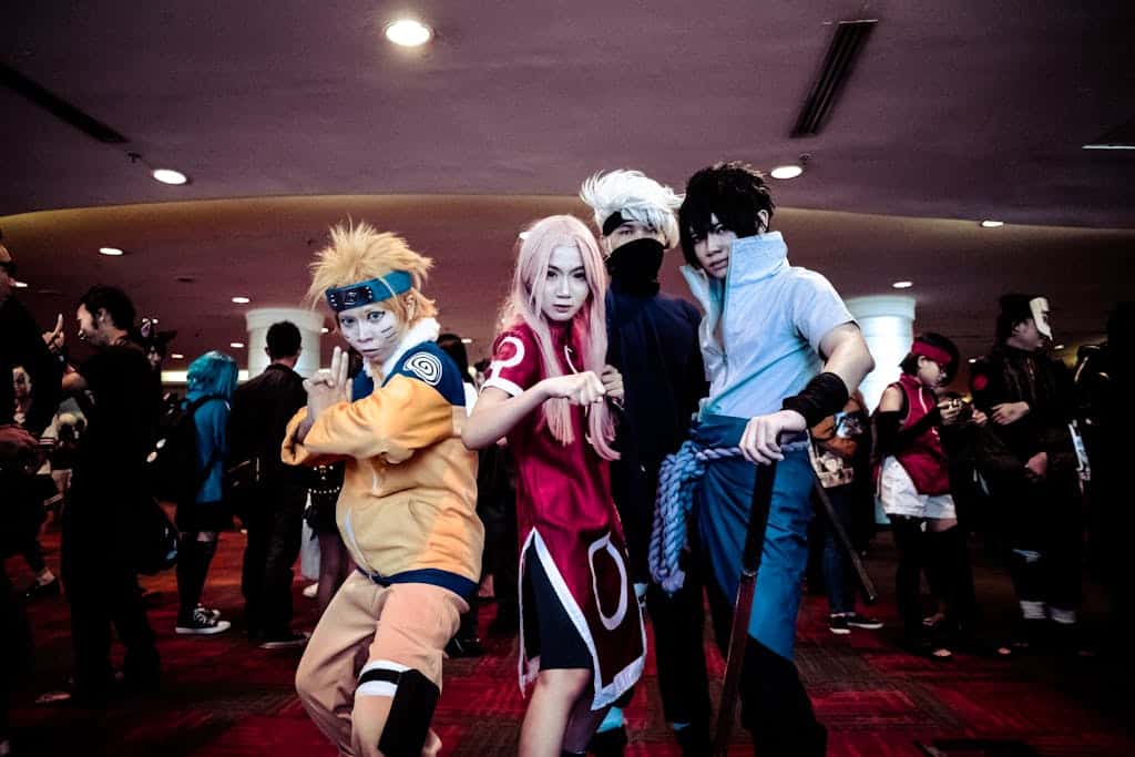A lively group of cosplayers in naruto anime costumes posing at an indoor convention event.