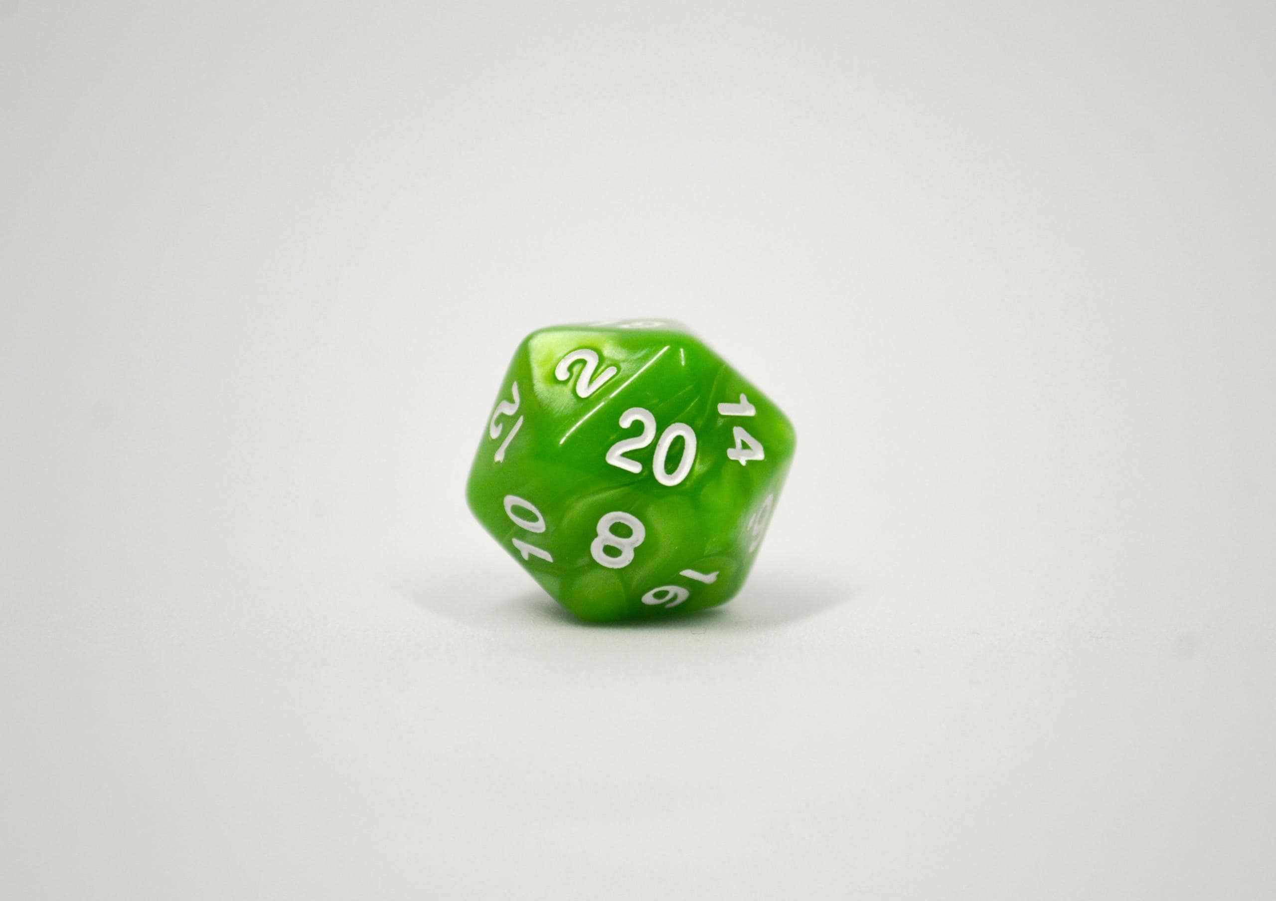 Close-up image of a green 20-sided dice used in tabletop role-playing games.